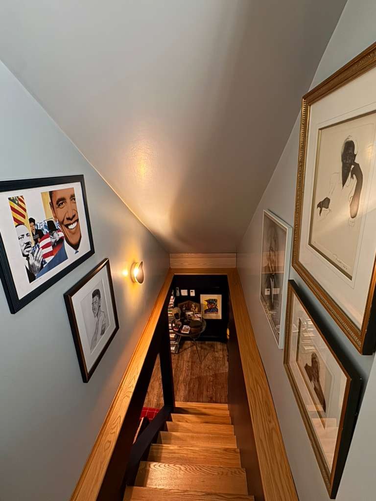 Art-lined staircase leading down to the speakeasy